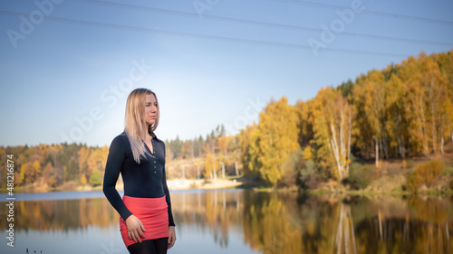 Beautiful girl against the background of the autumn forest and a beautiful lake