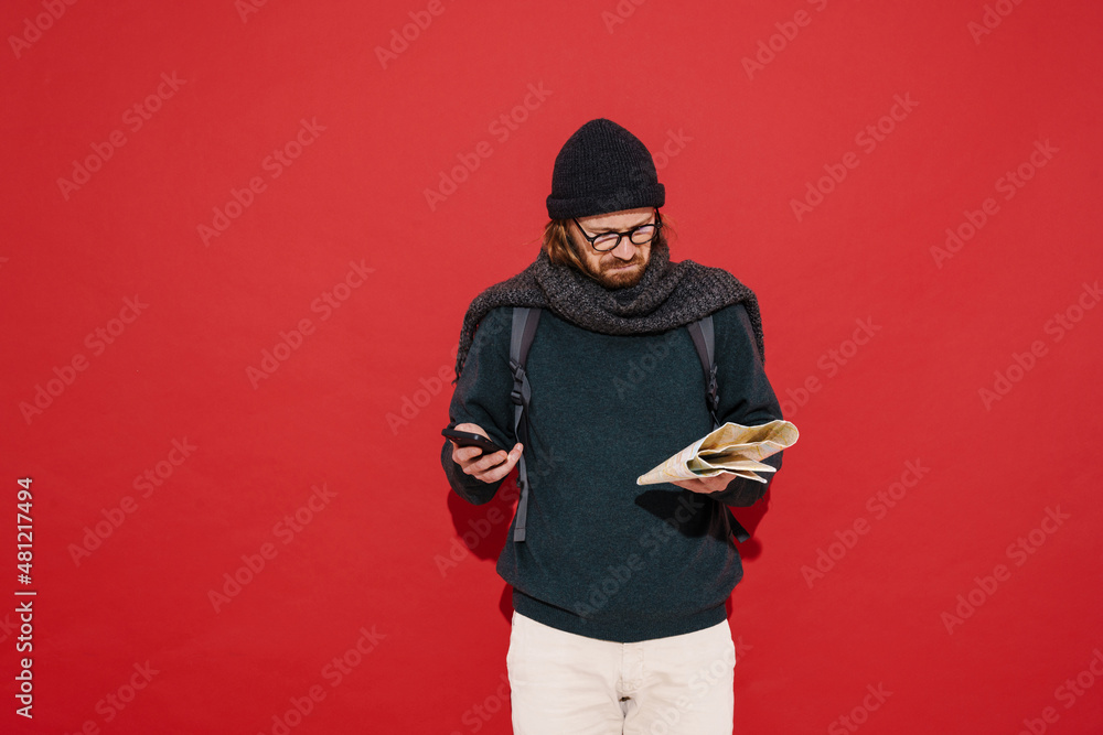 Ginger puzzlement man wearing hat and scarf using mobile phone Ginger puzzlement man wearing hat and scarf using mobile phone