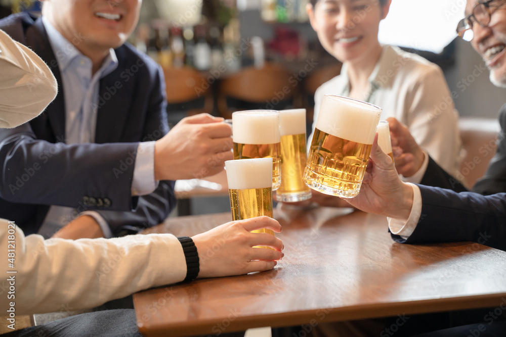 ビールで乾杯する会社帰りの打ち上げ飲み会手元