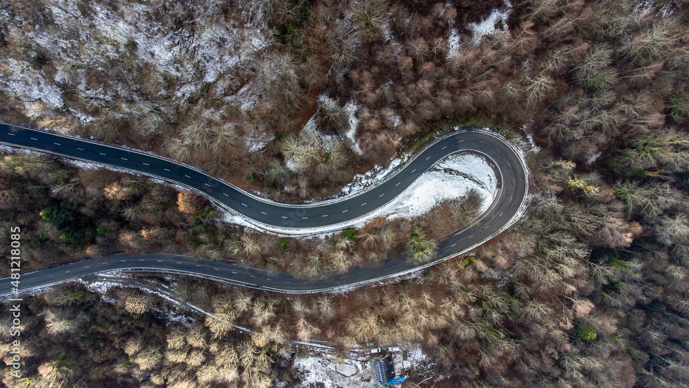 Aerial view of the road between the pines. winter landscape in the mountains