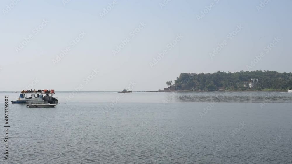 HD scenery of the Mandovi river and marina in Goa with fishing vessel and a yacht in the foreground HD scenery of the Mandovi river and marina in Goa with fishing vessel and a yacht in the foreground