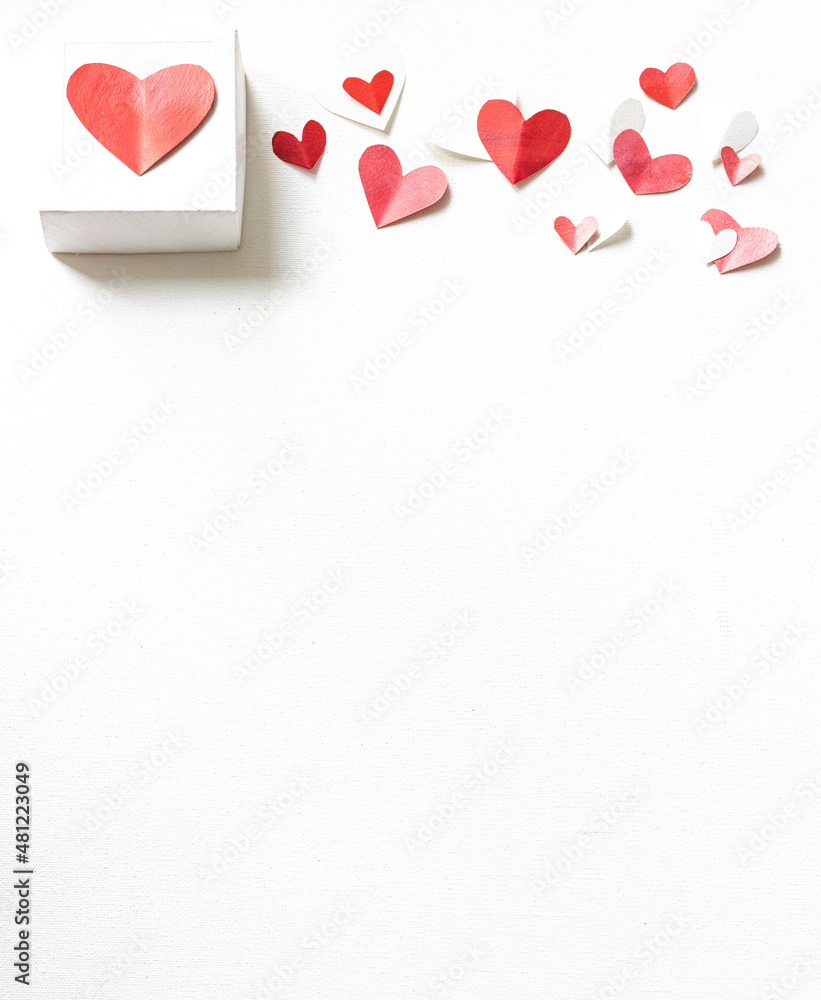 Valentines Day gift box, scattered painted small cut out red, pink and white hearts vertical with vertical copy space