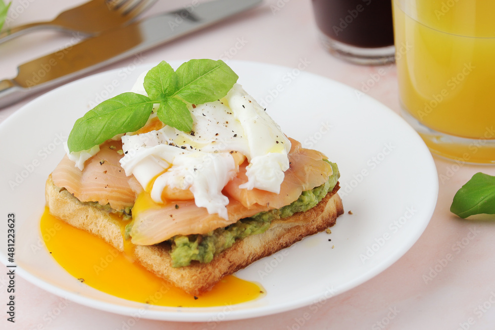 Breakfast with a sandwich with poached egg and avocado	