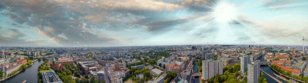 Panoramic aerial view of Berlin skyline at sunset with major city landmarks along Spree river, Germany from drone in summer season.