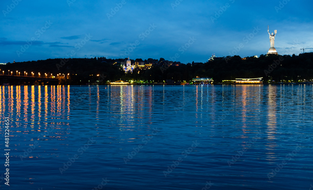Obraz premium View of Mother Motherland monument above Dnipro river with Paton bridge and Kiev city at sunset, Ukraine.