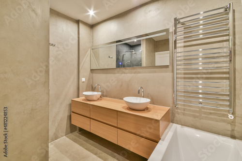Bathroom with sink on cabinet and mirror heated towel rails
