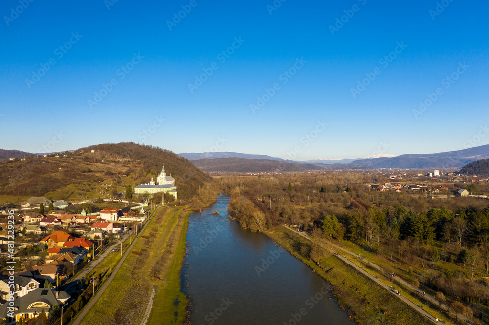 Obraz premium The Mukachevo city at the evening with beautiful mountains aerial view