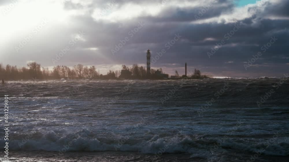 Stormy weather by the sea in Riga, Latvia. Huge waves crashing down the coast of Latvia near the lighthouse at sunset. Stormy weather by the sea in Riga, Latvia. Huge waves crashing down the coast of Latvia near the lighthouse at sunset.