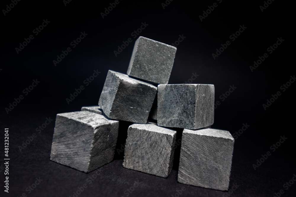 Stones for cooling drinks in the form of a pyramid stand on a dark background. Stones for whiskey. High quality photo Stones for cooling drinks in the form of a pyramid stand on a dark background. Stones for whiskey. High quality photo