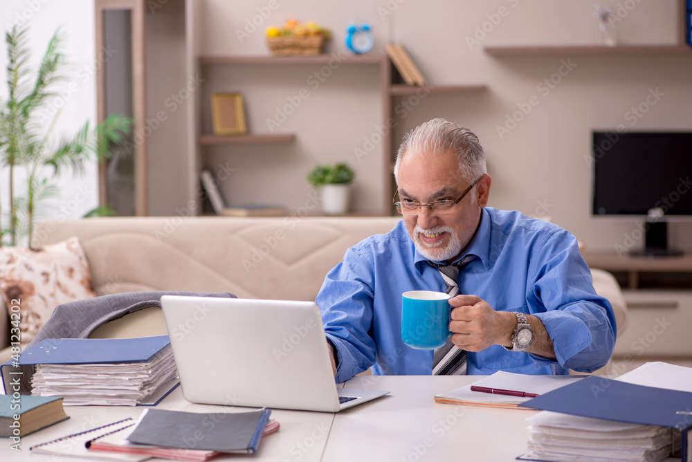 Old male employee working from home during pandemic