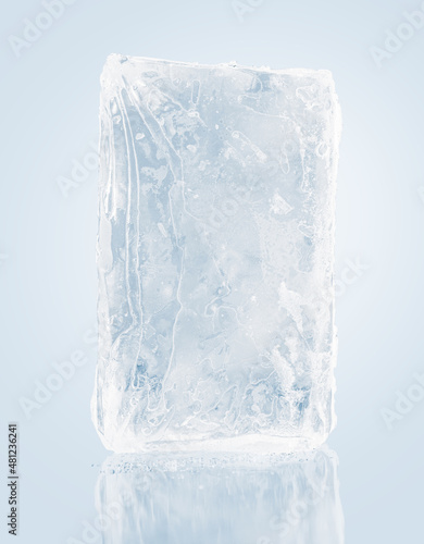 A translucent rectangular block of pure ice, on a light background with reflection. Purity and freshness concept.