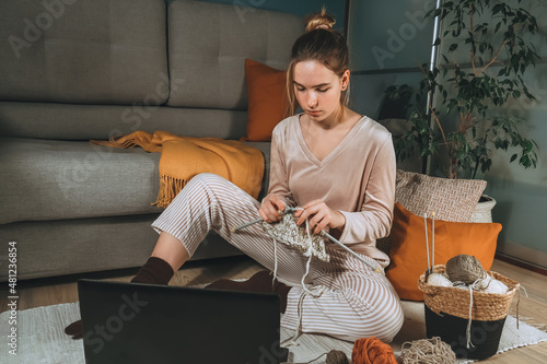 Girl knitting at home.Handmade zero waste,upcycling,New small business employment opportunity concept.Hobby knitting and needlework for mental health.Knitted background photo