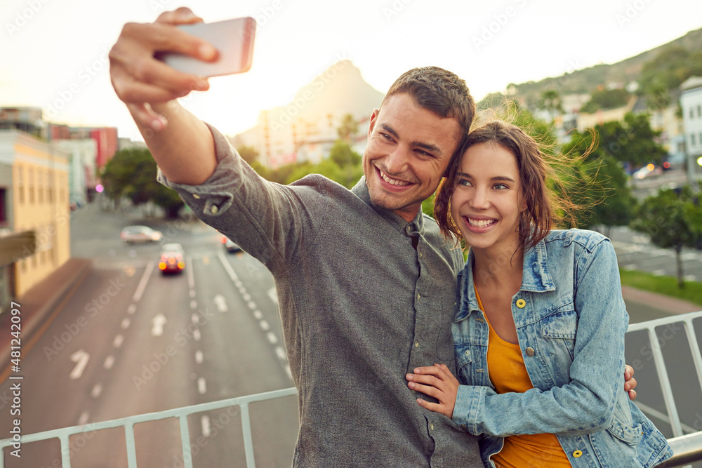 Naklejka premium Sentimental selfies. Shot of a happy young couple taking a selfie together in the city.