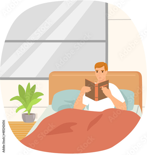 Cute man in pajamas reading literature on his bed comfortably. Book lover concept with young man lying relax on sofa and reading book. Concept of homeward and comfort. Person relaxes after work