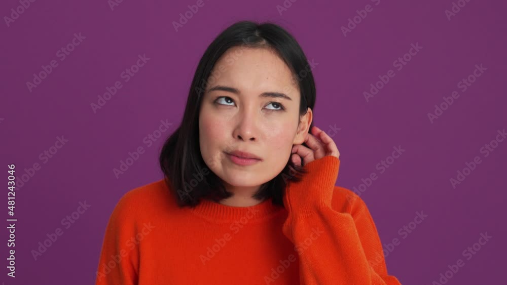 Displeased woman showing a gesture that she can't hear in the purple studio Displeased woman showing a gesture that she can't hear in the purple studio