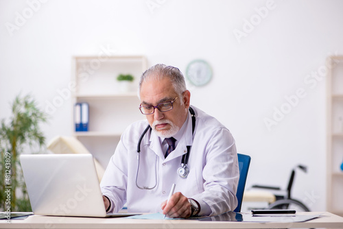 Old male doctor working at the hospital