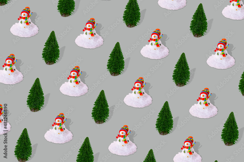 Creative winter pattern made of snowman with snow and pine tree on gray background. Creative winter pattern made of snowman with snow and pine tree on gray background.