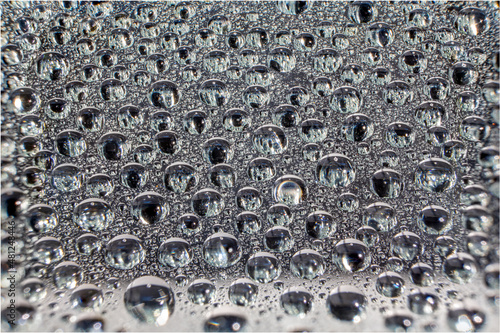 Water droplets on a glass in form of lenses with a colourful background. Wallpaper for screen. Abstract background.