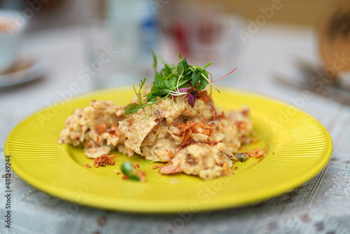 Mashed potatoes with cracklings in a yellow plate.