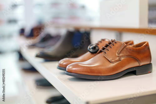 Cognac-colored leather men's shoes in a shoe store.