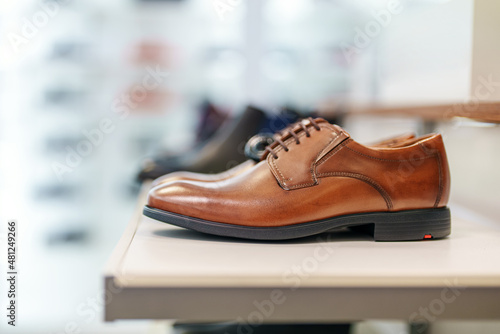 Cognac-colored leather men's shoes in a shoe store.