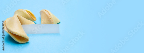 Banner with fortune cookies on a blue background and place for text. Mockup. Blank paper for writing a fortune. Copy space.