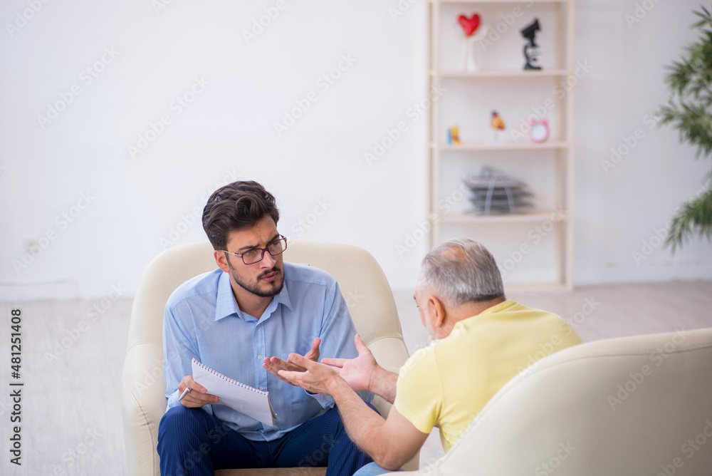 Old man visiting young male psychotherapist Old man visiting young male psychotherapist