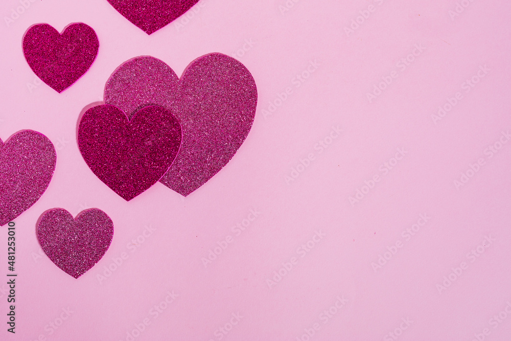 Heart shapes with glitter in different colors on a purple background in combination with ring box, chocolate or red rose. Nice and simple Valentine's day or engagement concept,