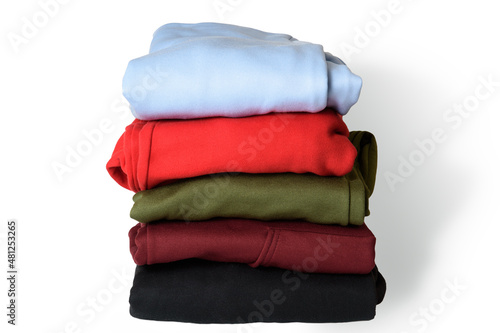 Obraz na płótnie Stack of folded hoodie and hooded sweatshirts on white background. Trendy comfortable casual clothes. Closeup. w salonie