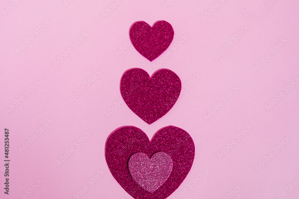 Heart shapes with glitter in different colors on a purple background in combination with ring box, chocolate or red rose. Nice and simple Valentine's day or engagement concept,