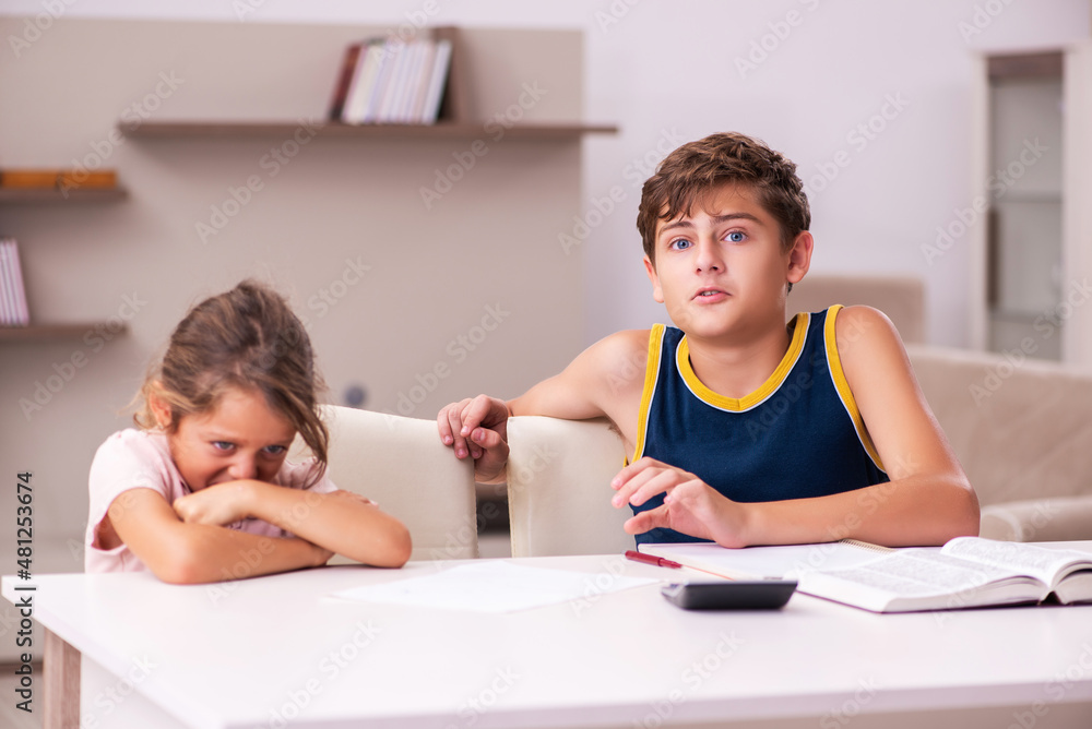 Schoolboy and his small sister staying at home during pandemic Schoolboy and his small sister staying at home during pandemic