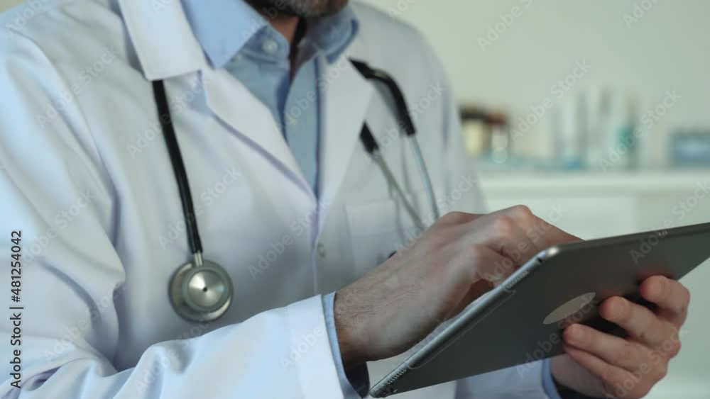Fingers typing and touching tablet. Male doctor in white coat working with health software close-up side view. Distance consultation. Social media concept. Faceless. 4k footage Fingers typing and touching tablet. Male doctor in white coat working with health software close-up side view. Distance consultation. Social media concept. Faceless. 4k footage