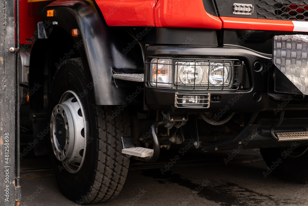 Cropped view of the fire truck of red color with retractable ladders standing at the garage. Emergency concept. Stock photo Cropped view of the fire truck of red color with retractable ladders standing at the garage. Emergency concept. Stock photo
