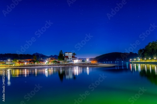 Entrance to the port of Ribadesella, with Santa Marina beach in the background, on a starry night.