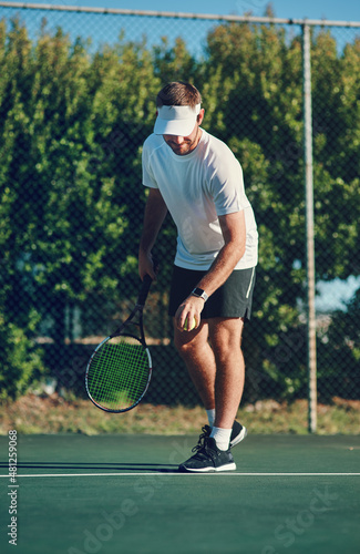 Have fun and enjoy the game. Shot of a sporty young man playing tennis on a tennis court. © Allistair F/peopleimages.com