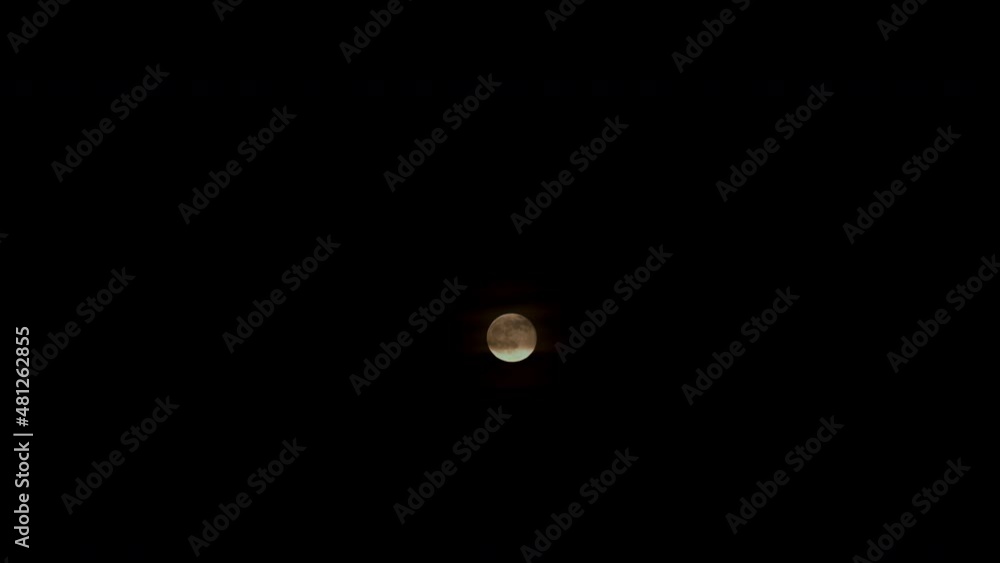 Timelapse of hazy full moon rising in the night against dark sky Timelapse of hazy full moon rising in the night against dark sky