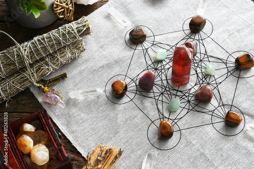 A top view image of a crystal healing grid using sacred geometry and a strawberry quartz tower.  photo