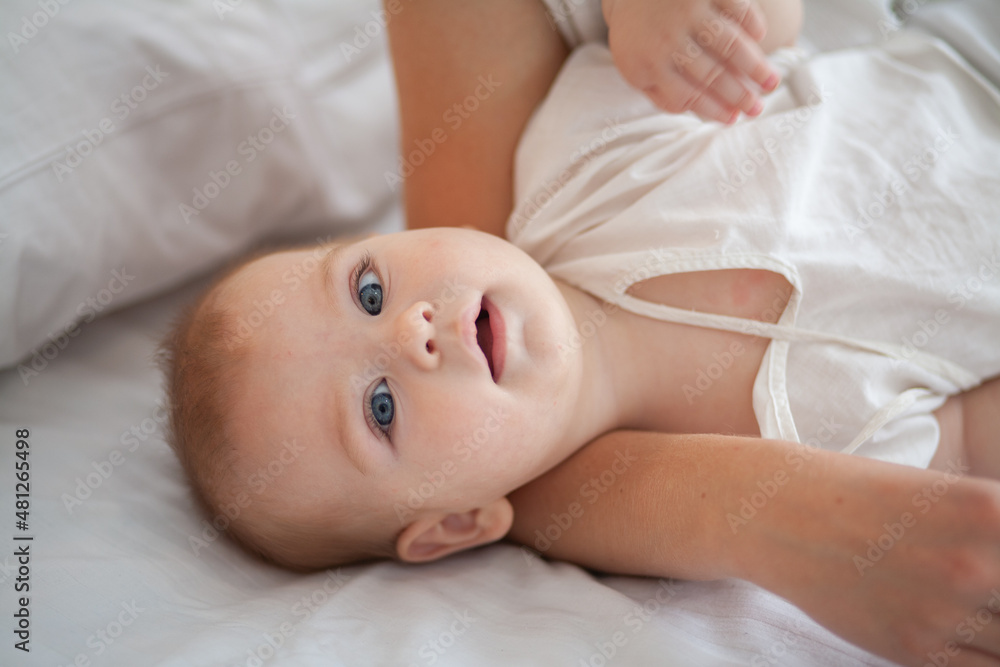 Little newborn baby lies on a white fluffy bedspread.
Little newborn baby lies on a white fluffy bedspread.