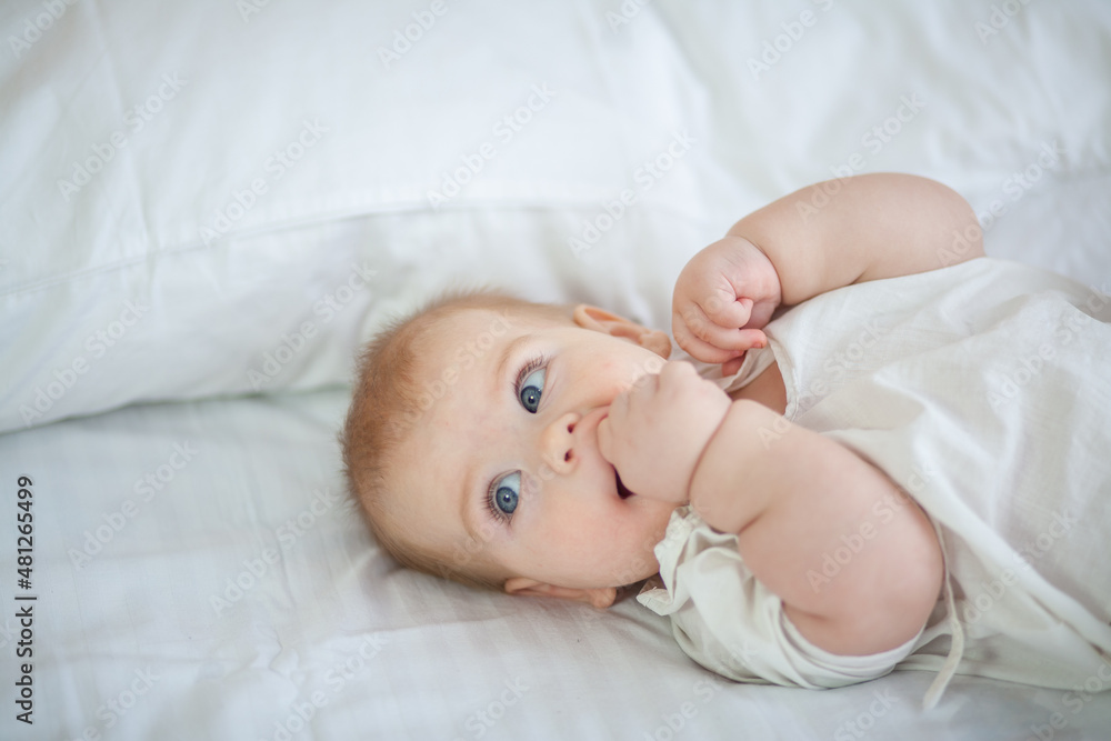 Little newborn baby lies on a white fluffy bedspread.
Little newborn baby lies on a white fluffy bedspread.