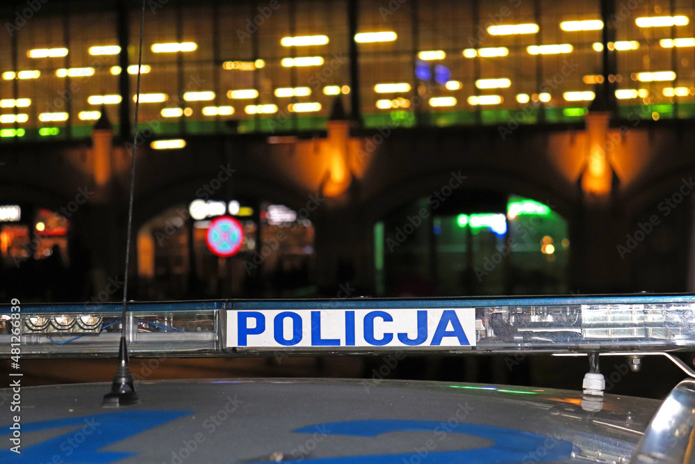 Sygnalizator błyskowy niebieski na dachu radiowozu policji polskiej w nocy na drodze.  - obrazy, fototapety, plakaty 