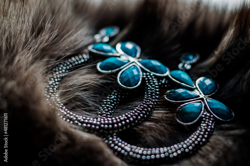 beautiful earrings lie on a fur coat. elegant composition.
