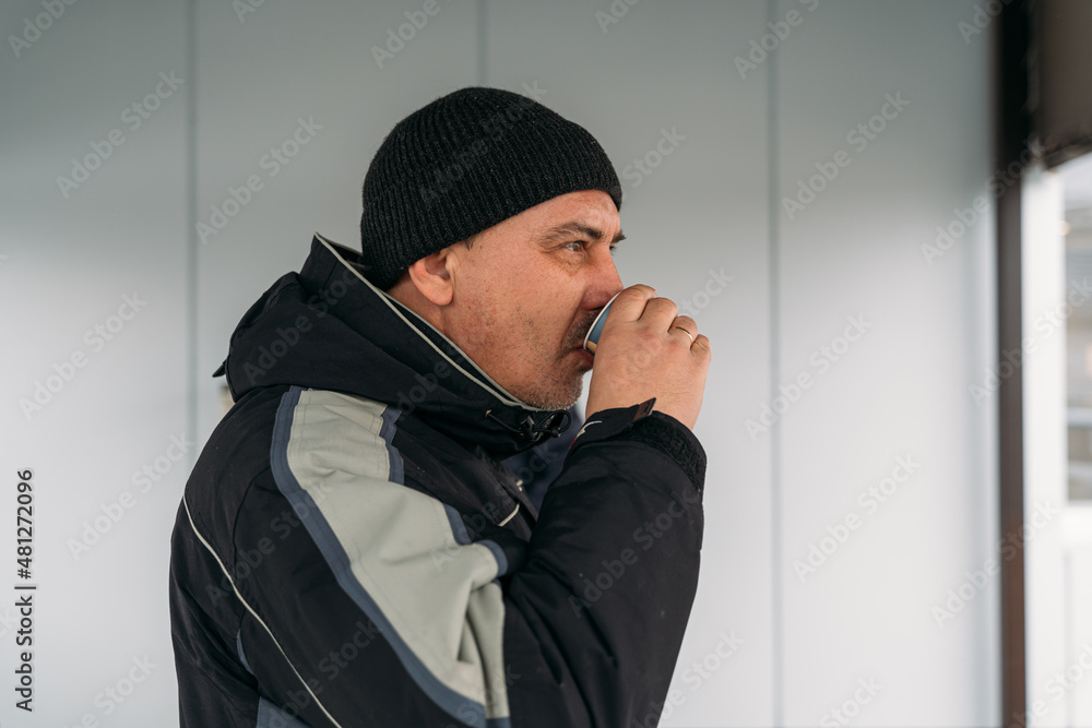 Middle Age Man drinking Coffee outdoors in a cold day