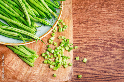 Photos Whole and chopped fresh green beans on a cutting board