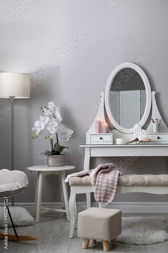 Wooden dressing table with decorative elements and makeup products in room Fototapet