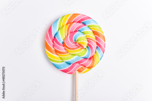 A colored lollipop on a stick. Sweet dessert. Confectionery background. Copy space. Flat lay, top view