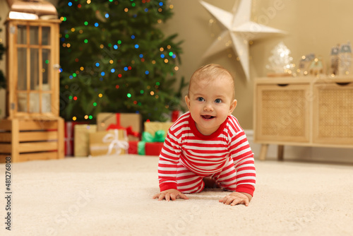 Cute little baby in room decorated for Christmas. Winter holiday