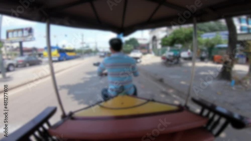Blurred defocused POV of a tourist in a tuk tuk in Siem Reap driving through its streets. A local taxi takes tourists through the streets of Cambodia a Southeast Asian city photo