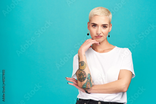 My style, my choice. Studio shot of an attractive young woman posing against a turquoise background. photo