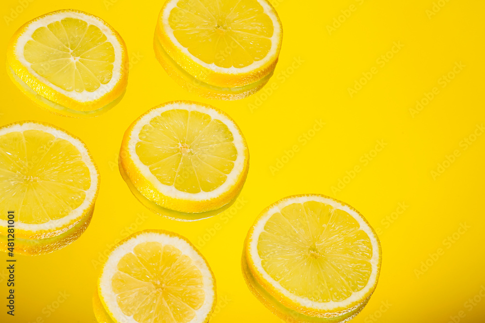 Sliced lemons with yellow background. Bright and minimal citrus fruits isolated with copy space for advertisement. Lemon slices for sour and juicy concept.