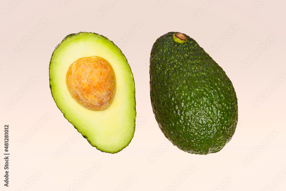Clean isolated avocado on minimal background. Preparing and cooking ingredients for guacamole. Sliced and whole avocado. Vegetarian and organic diet.